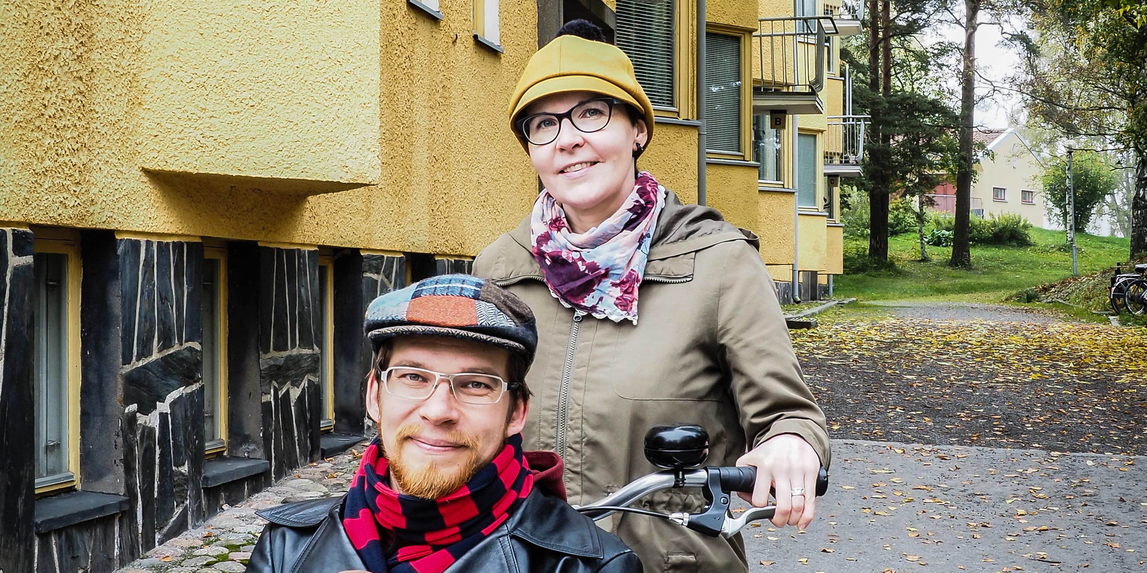 Kuvassa Tuula ja Matti Koistinen kerrostalon pihalla polkupyörä mukanaan.