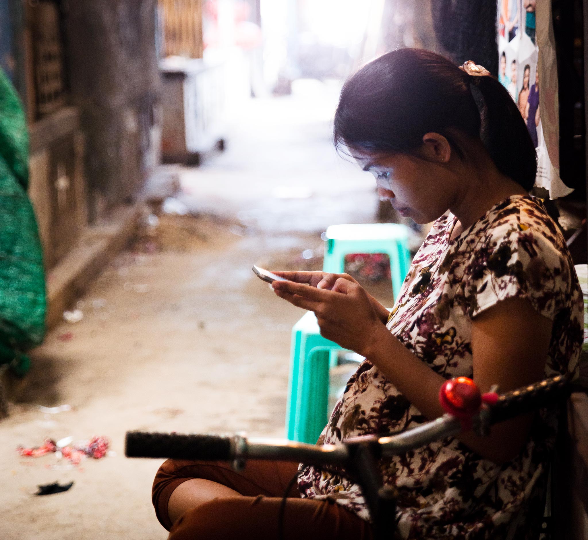 Kuvassa nainen selailee älypuhelintaan. 