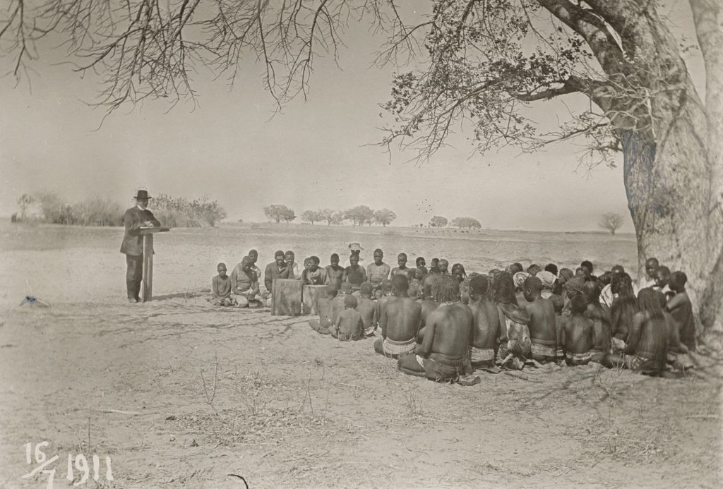 Vanha valokuva, jossa mies saarnaa väkijoukolle
