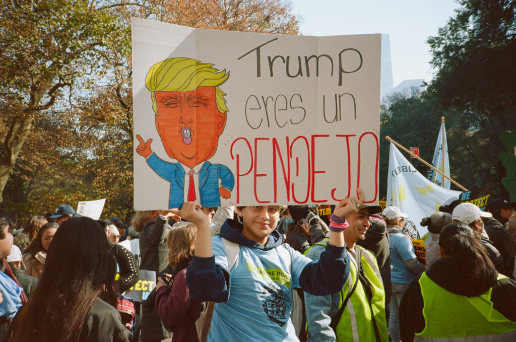 Mielenosoittaja, joka pitelee Trump-vastaista kylttiä