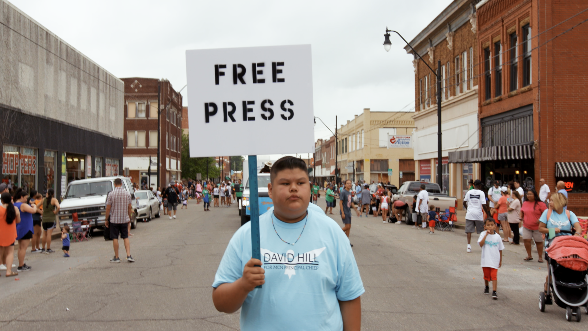 Poika mielenosoituskyltin kanssa, teksti Free Press.