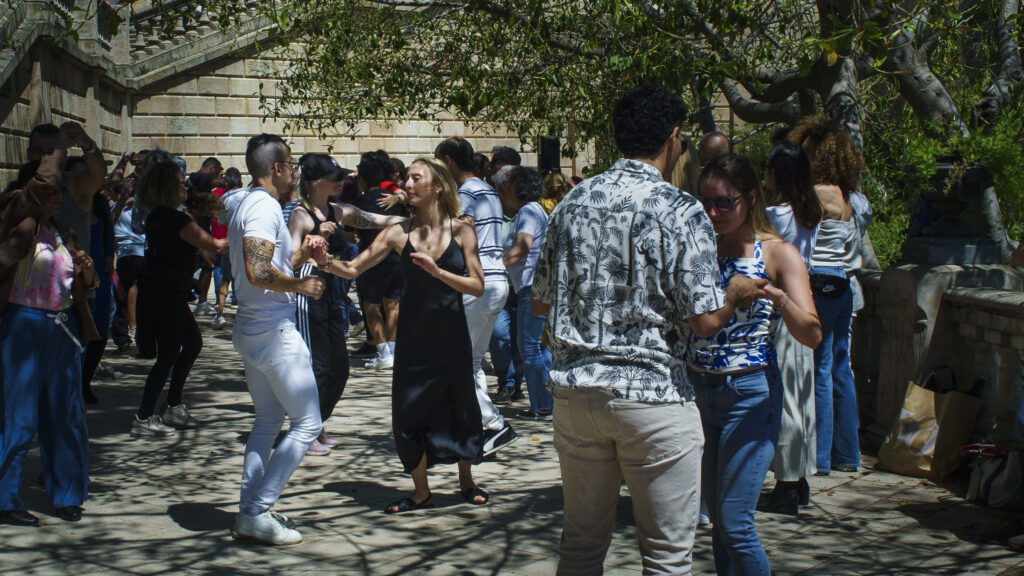 Iso joukko ihmisiä tanssimassa salsaa puistossa Barcelonassa.