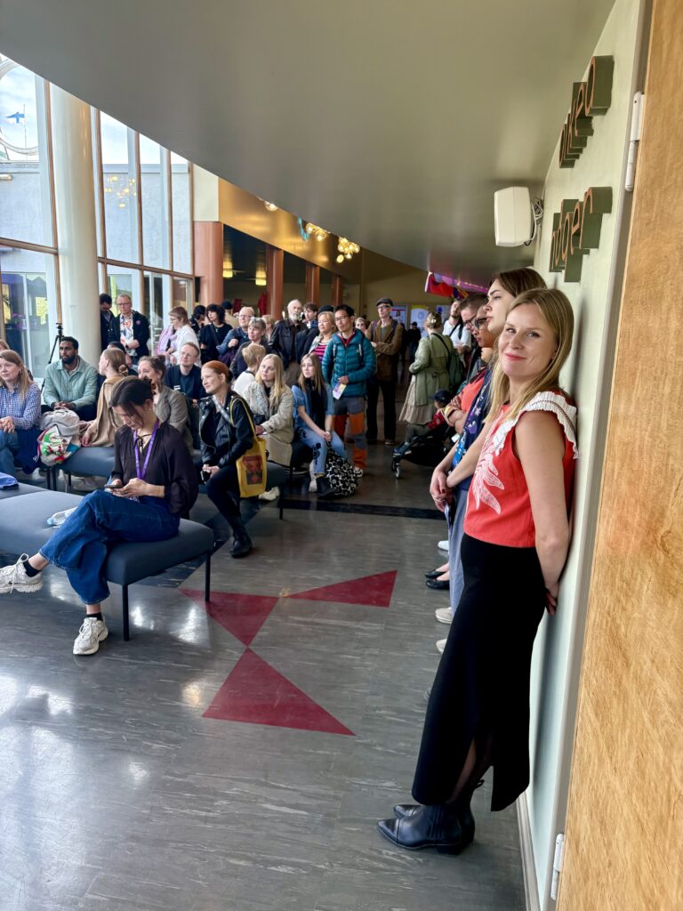 Maija Salmi ja keskustelua kuuntelevaa yleisöä.