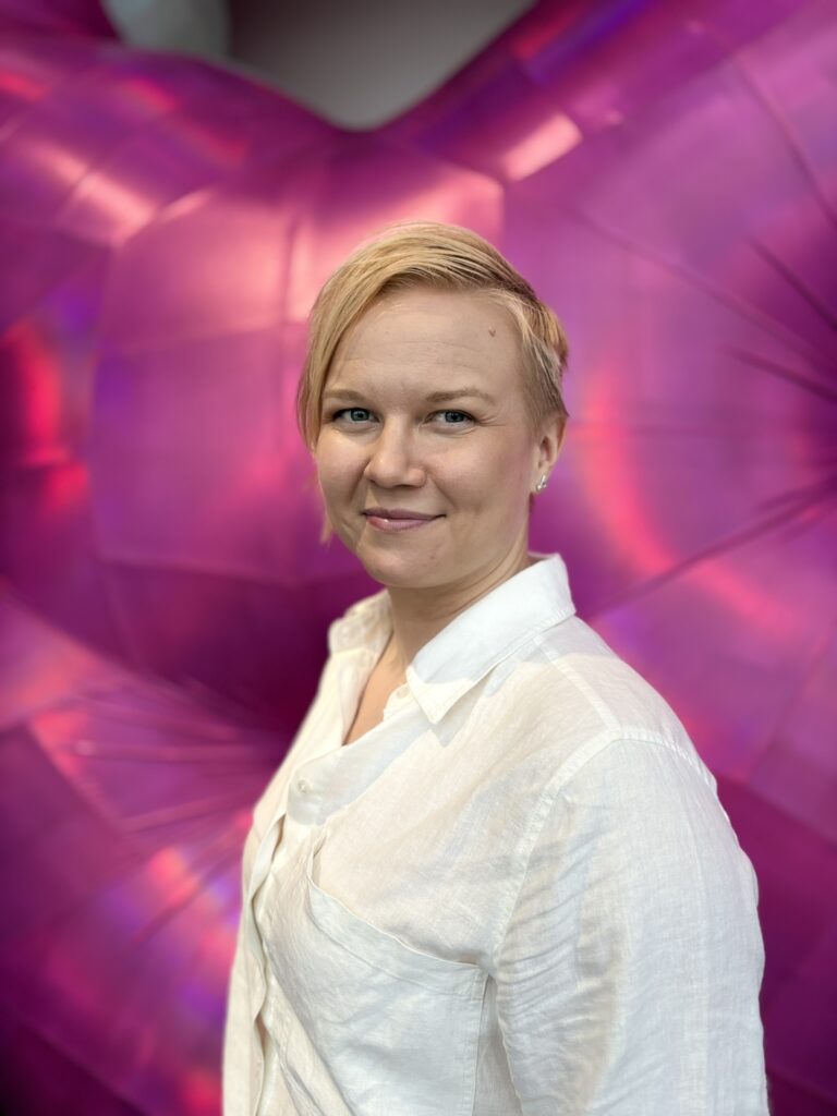 Salla-Maaria Laaksonen puolilähikuvassa purppuranvärisellä alustalla.