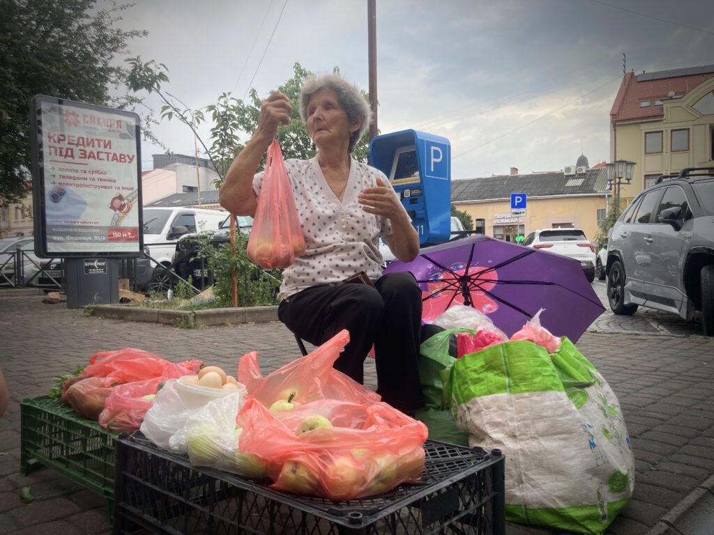 ukrainalainen eläkeläinen elizabeth nostaa hedelmäpussia parkkipaikalla